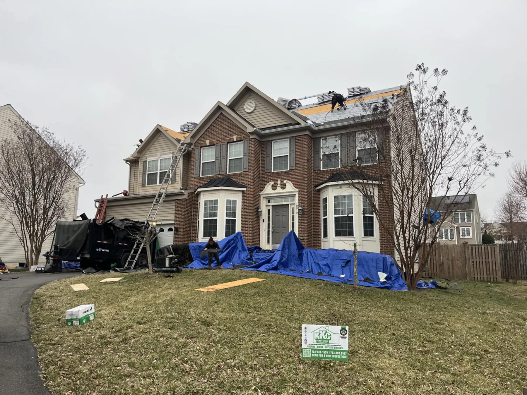 Roof replacement in progress with landscape protection in place