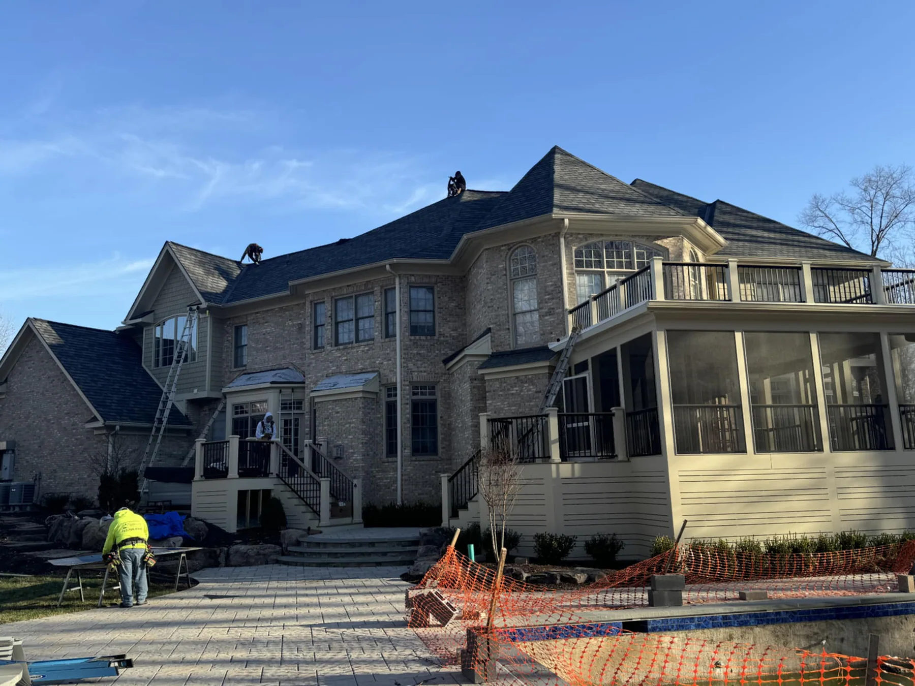 Roofing crew completing detailed work on a multi-level home