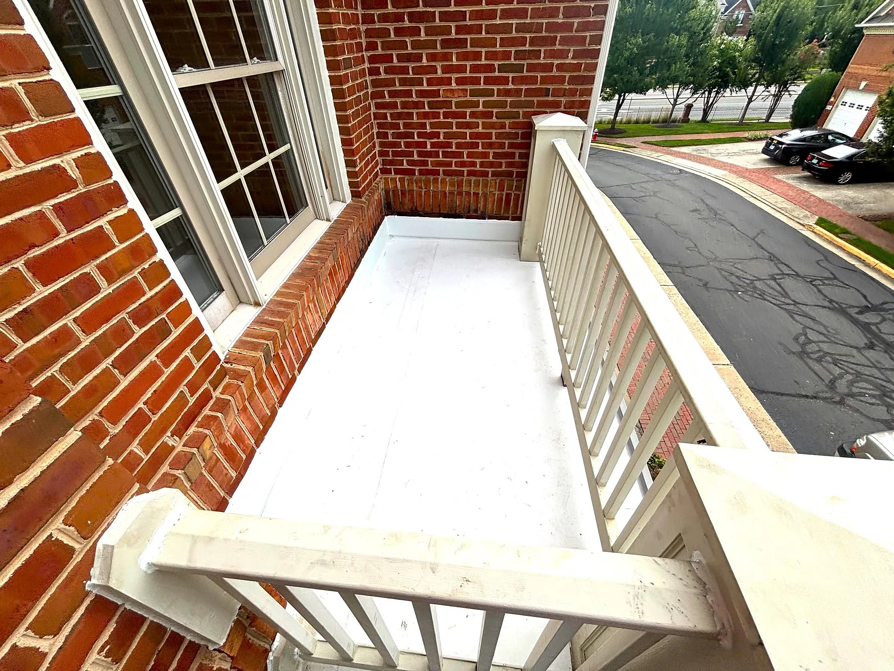 Completed white low-slope roof membrane at a brick home